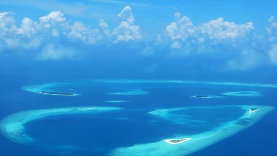 An atoll is a grouping of islands that forms a ring around a central lagoon. The Maldives is made up of more than 1,000 islands comprising 26 atolls.