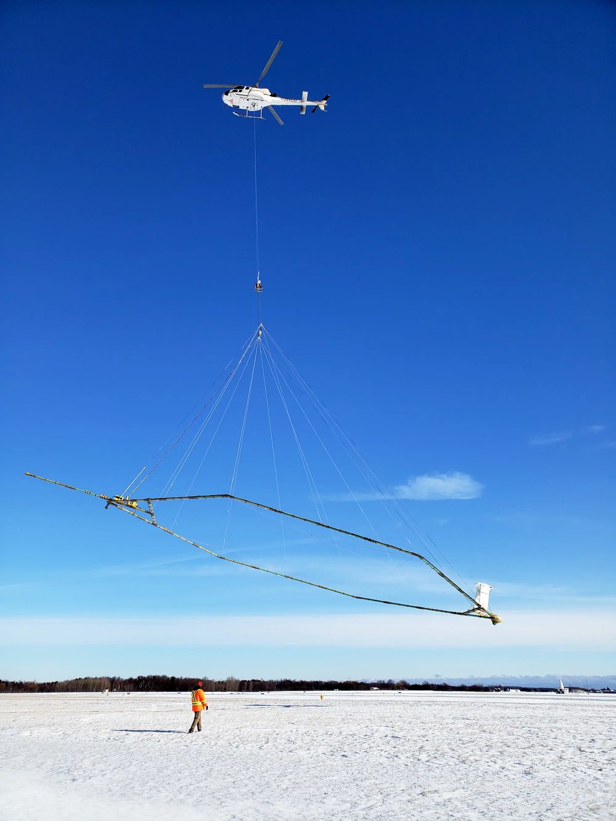 A helicopter carries an airborne electromagnetic induction sensor over parts of northeastern Wisconsin for a USGS study in January 2021. A helicopter carries an airborne electromagnetic induction sensor over parts of northeastern Wisconsin for a USGS study in January 2021.