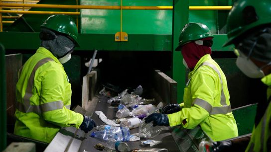 Workers sort plastic on the curbside-recyclables processing line at the Green Waste material recovery facility in San Jose, California, in 2019.