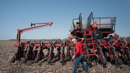 An Illinois farmer uses a tractor to plant soybeans.